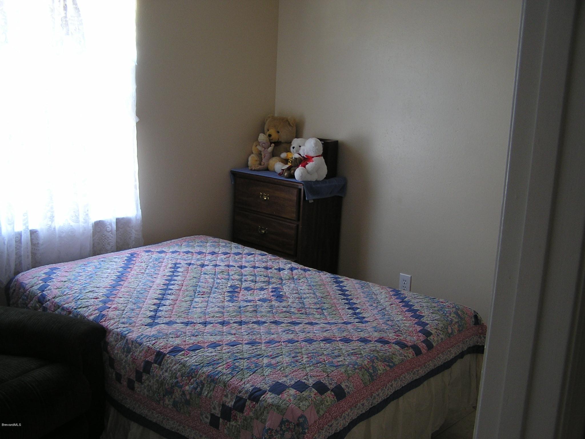 6474 Hudson Road Cocoa, FL 32927 - Photo 7 of 9 a bedroom with a bed and dresser