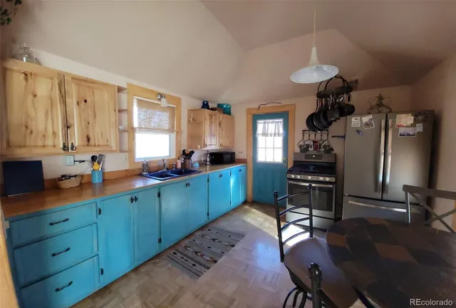 a kitchen with granite countertop a sink appliances cabinets and furniture