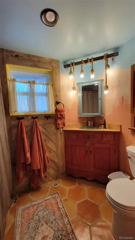 a bathroom with a toilet sink and mirror