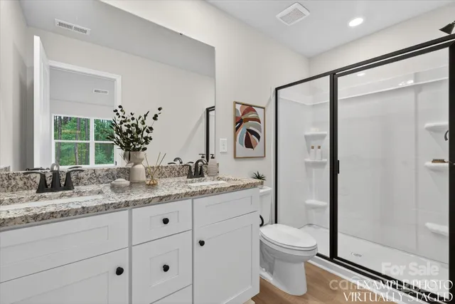 a bathroom with a granite countertop sink toilet and shower