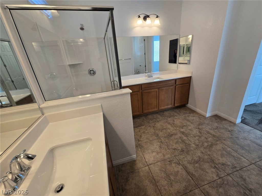 4748 Ritual Street North Las Vegas, NV 89031 - Photo 10 of 31 Step into a well-appointed bathroom featuring dual vanities and a spacious walk-in shower.