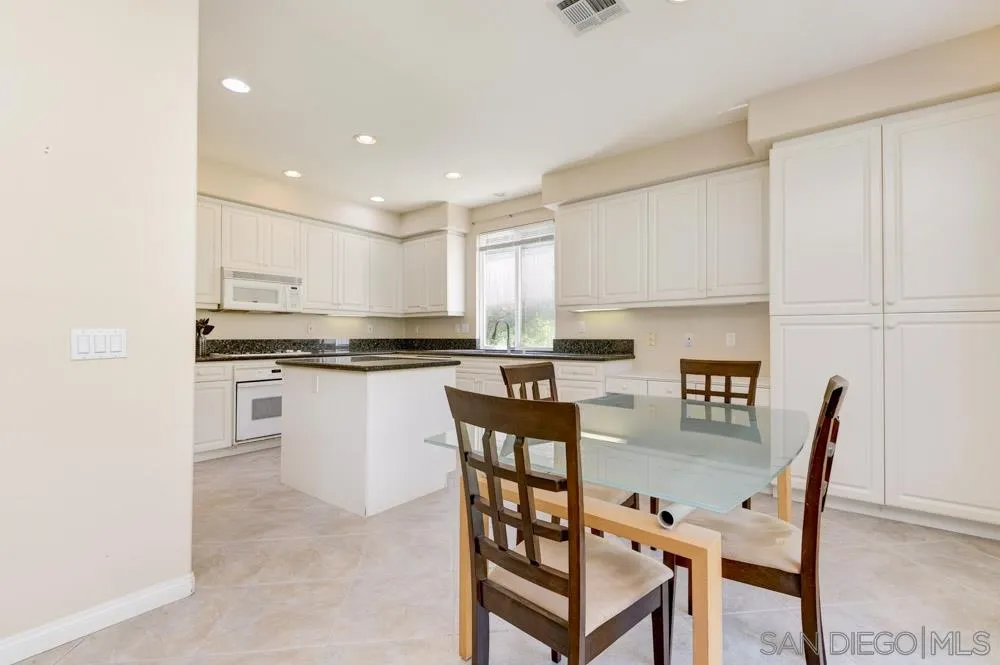 3224 Rancho Arroba Carlsbad, CA 92009 - Photo 13 of 35 a kitchen with a table chairs microwave and cabinets