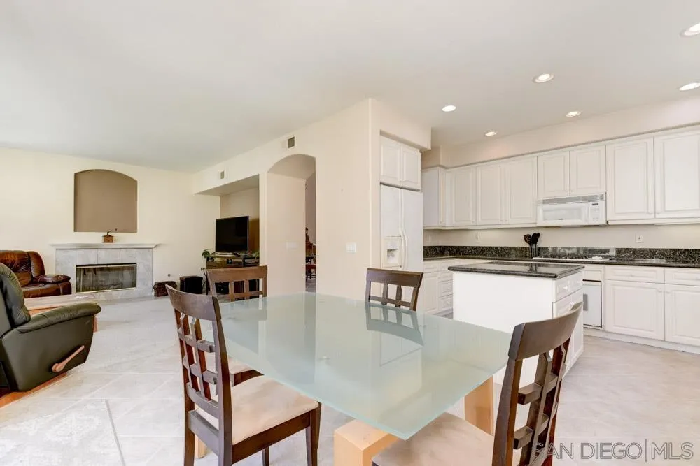 3224 Rancho Arroba Carlsbad, CA 92009 - Photo 15 of 35 a kitchen with stainless steel appliances granite countertop a stove a sink dishwasher a dining table and chairs with wooden floor