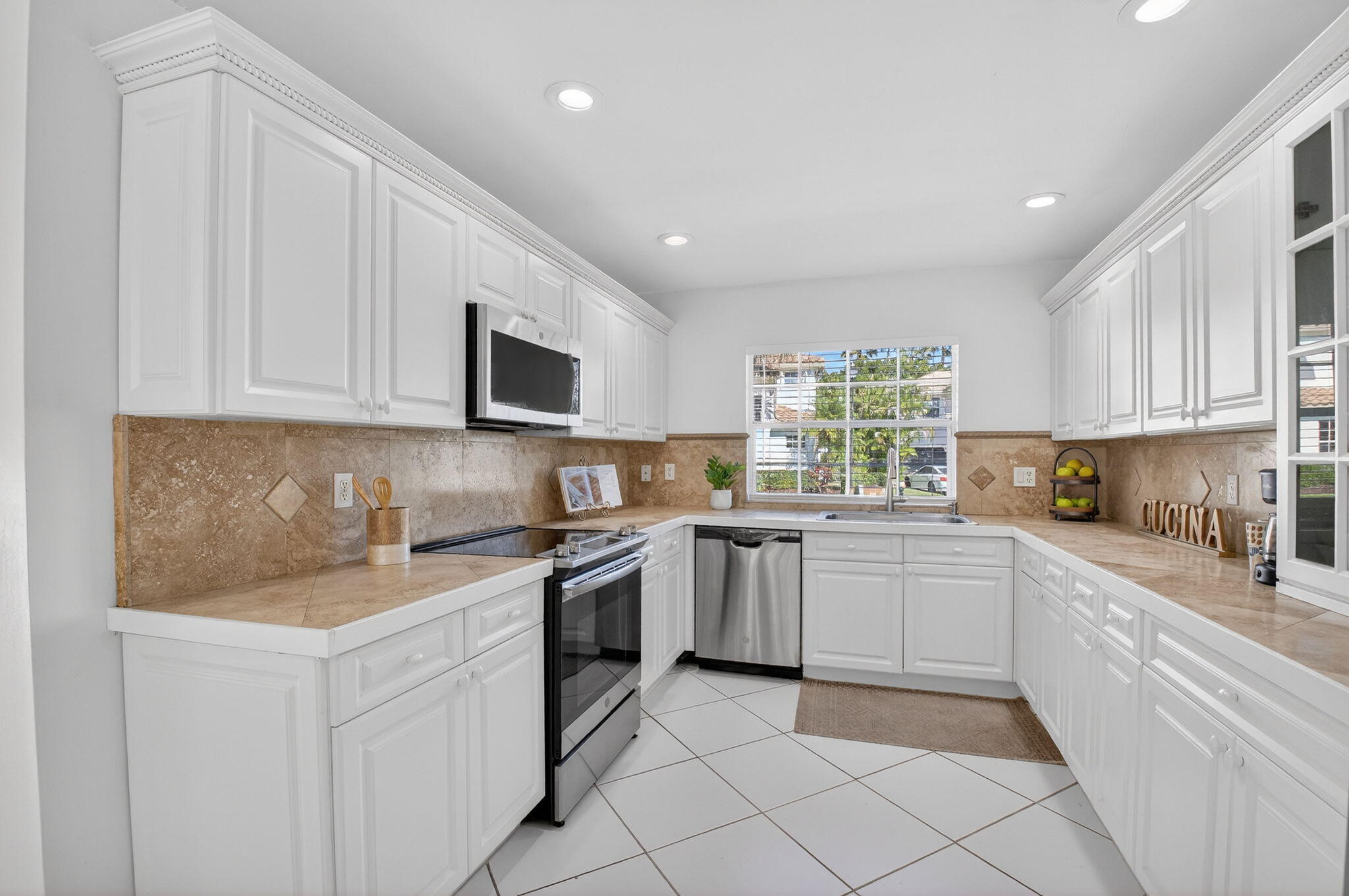 10570 Bexley Boulevard Boca Raton, FL 33428 - Photo 7 of 37 a kitchen with white cabinets appliances and a window