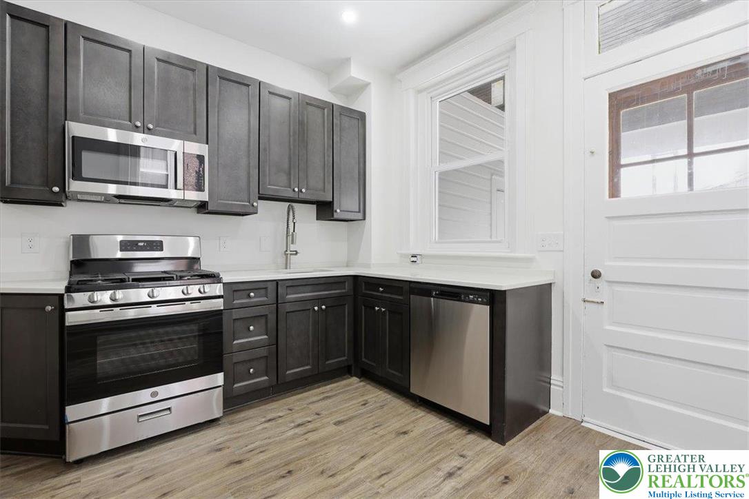 524 Fiot Street Bethlehem, PA 18015 - Photo 14 of 42 a kitchen with stainless steel appliances granite countertop a stove a microwave and a sink