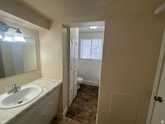 265 Rigdon Avenue, Unit 1 Salt Lake City, UT 84115 - Photo 13 of 15 Bathroom vanity featuring a single basin sink, chrome faucet, and a rectangular mirror