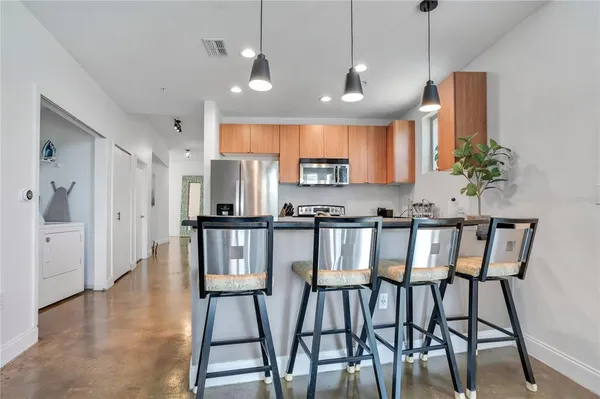 a kitchen with a sink and a stove with wooden floor