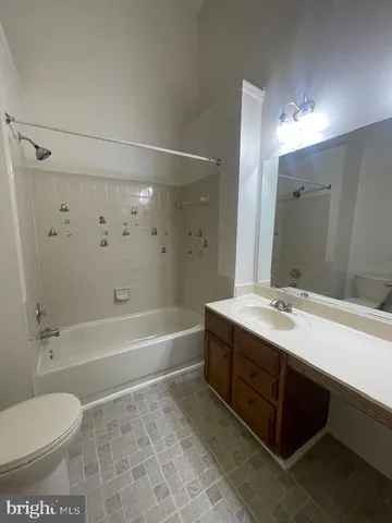 a bathroom with a sink toilet double vanity and bathtub