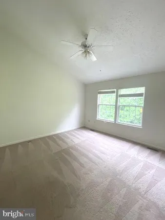 an empty room with closet and a ceiling fan