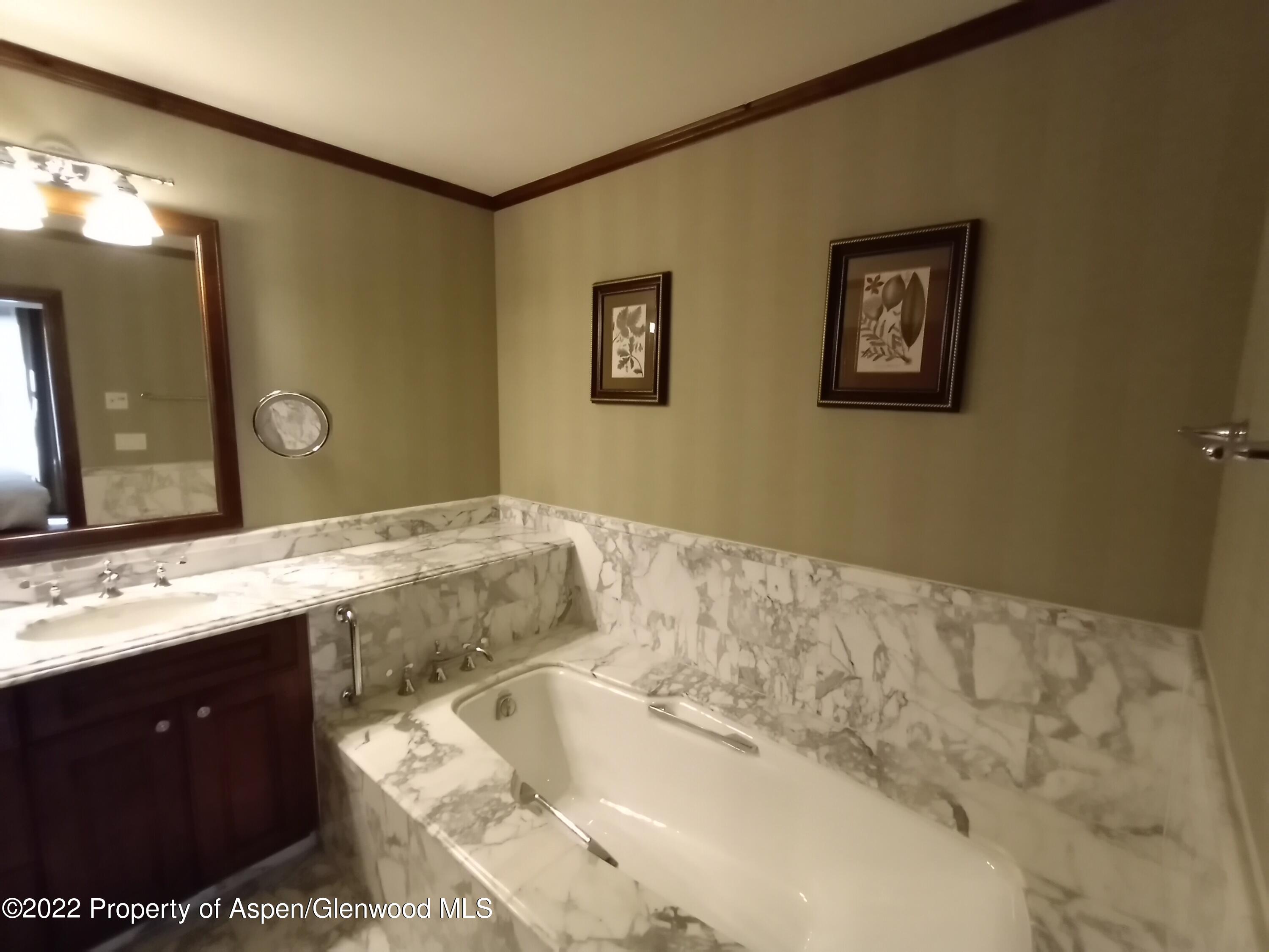 75 Prospector Road, Unit 8203 SUMMER INTEREST 9 Aspen, CO 81611 - Photo 15 of 28 a bathroom with a tub sink and mirror