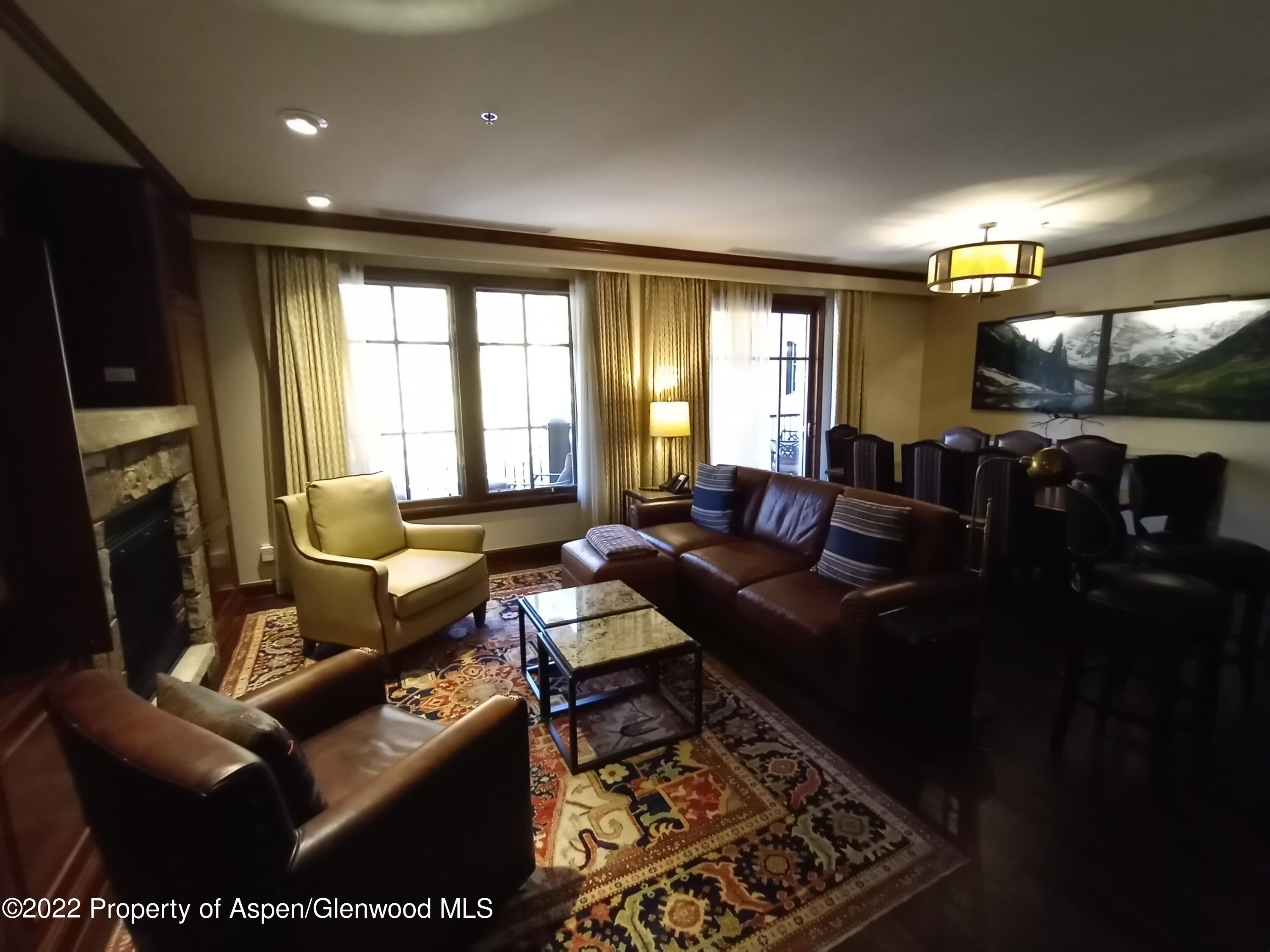 75 Prospector Road, Unit 8203 SUMMER INTEREST 9 Aspen, CO 81611 - Photo 5 of 28 a living room with furniture a flat screen tv and a fireplace