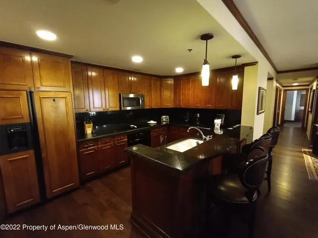 a kitchen with stainless steel appliances granite countertop a sink a stove and a refrigerator