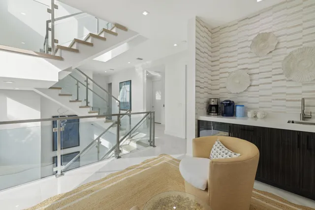 a living room with couches and kitchen view with wooden floor