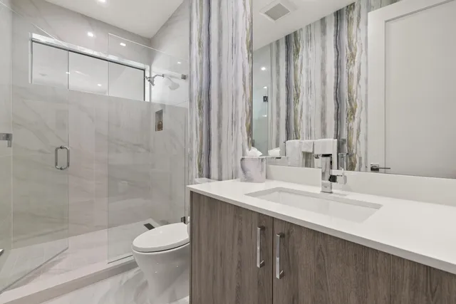 a bathroom with a sink a toilet and shower