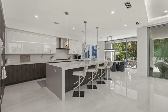 a kitchen with kitchen island granite countertop a table chairs sink and cabinets