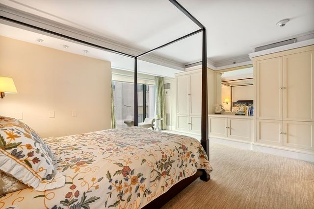 a bedroom with a large bed and a large mirror with wooden floor