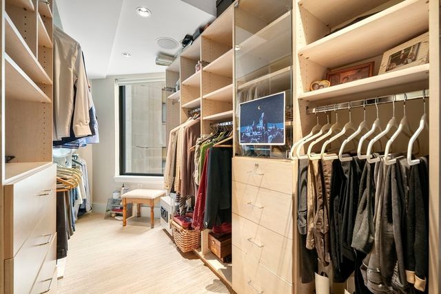 a view of walk in closet with clothes and shoes