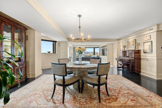 a dining room with furniture a chandelier and wooden floor