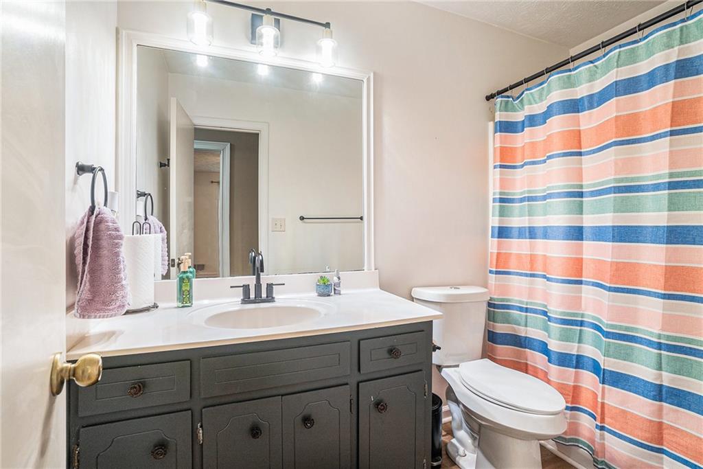 2247 Cruse Road Northwest Lawrenceville, GA 30044 - Photo 9 of 16 a bathroom with a sink toilet a mirror and shower curtain