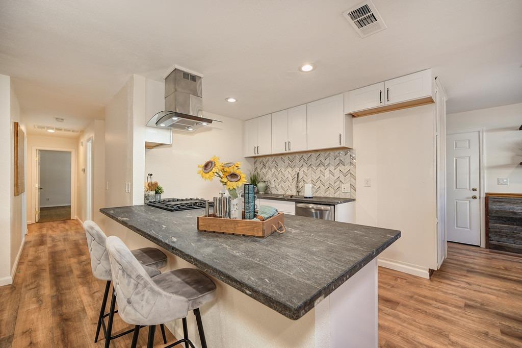 a kitchen with kitchen island a table and chairs in it