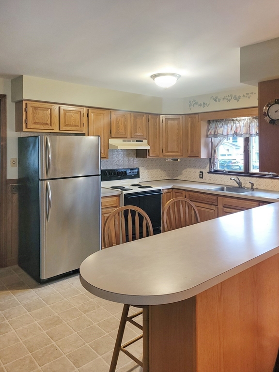 125 George Street Somerset, MA 02726 - Photo 7 of 9 a kitchen with stainless steel appliances a refrigerator a sink a stove a table and chairs