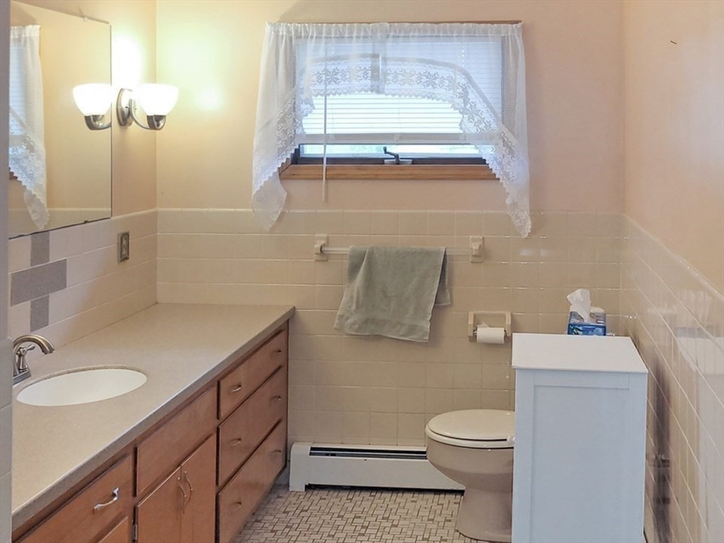 125 George Street Somerset, MA 02726 - Photo 9 of 9 a bathroom with a granite countertop sink a toilet and a mirror