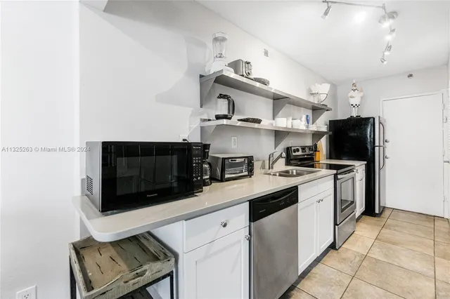 a kitchen with stainless steel appliances a stove microwave and refrigerator