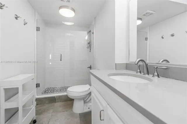 a bathroom with a sink toilet double vanity and shower