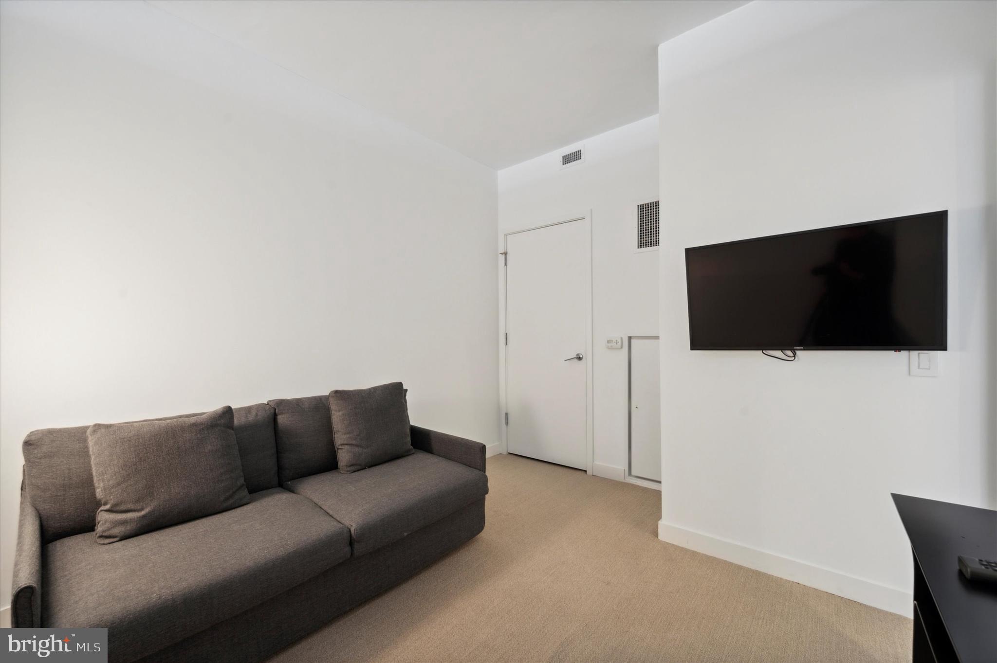 2930 Walnut Street, Unit 3613 Philadelphia, PA 19104 - Photo 21 of 33 a living room with a couch and a flat screen tv