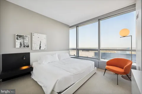 a bedroom with a bed and large window