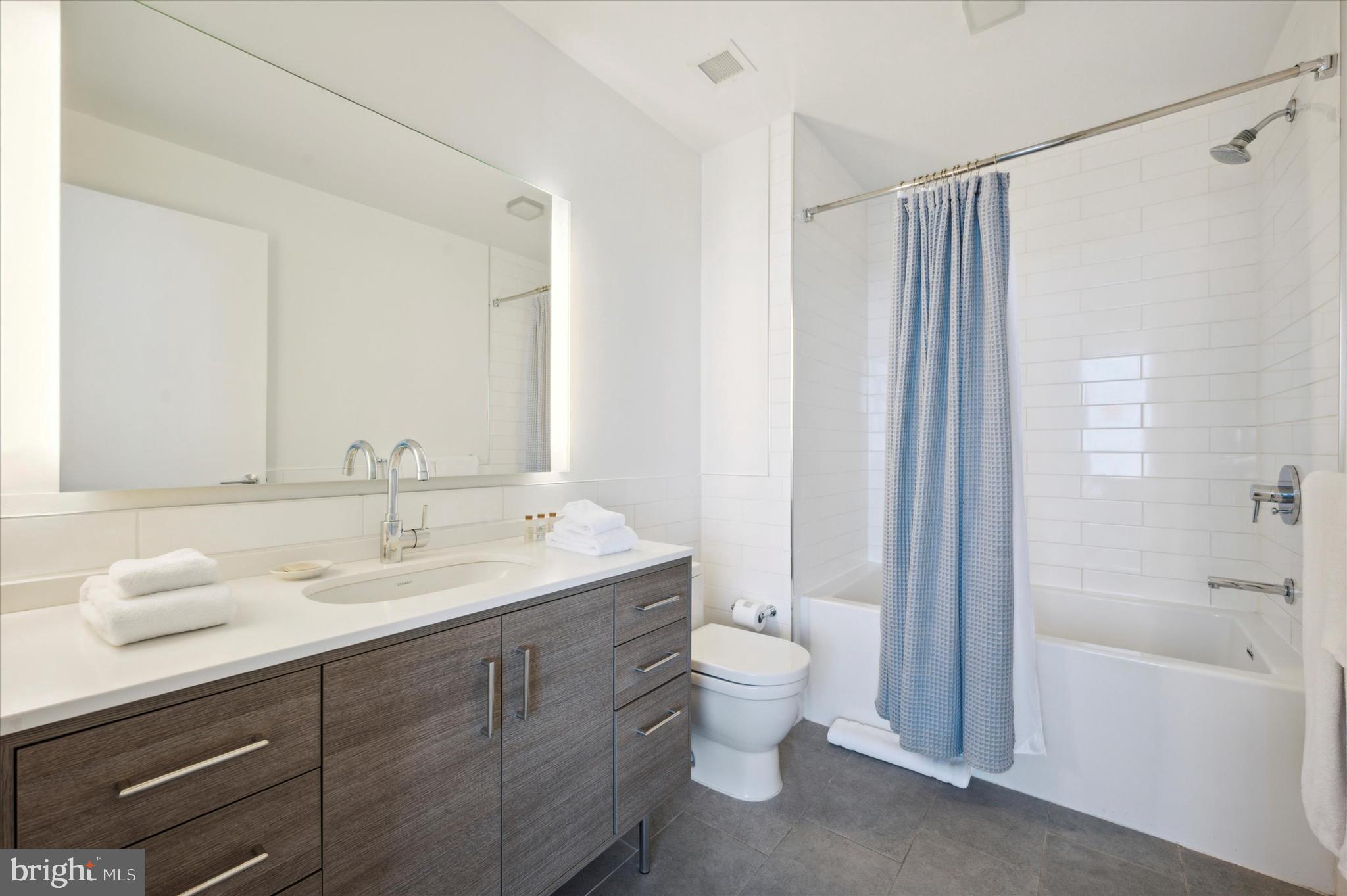 2930 Walnut Street, Unit 3613 Philadelphia, PA 19104 - Photo 26 of 33 a bathroom with a double vanity sink toilet mirror and bathtub