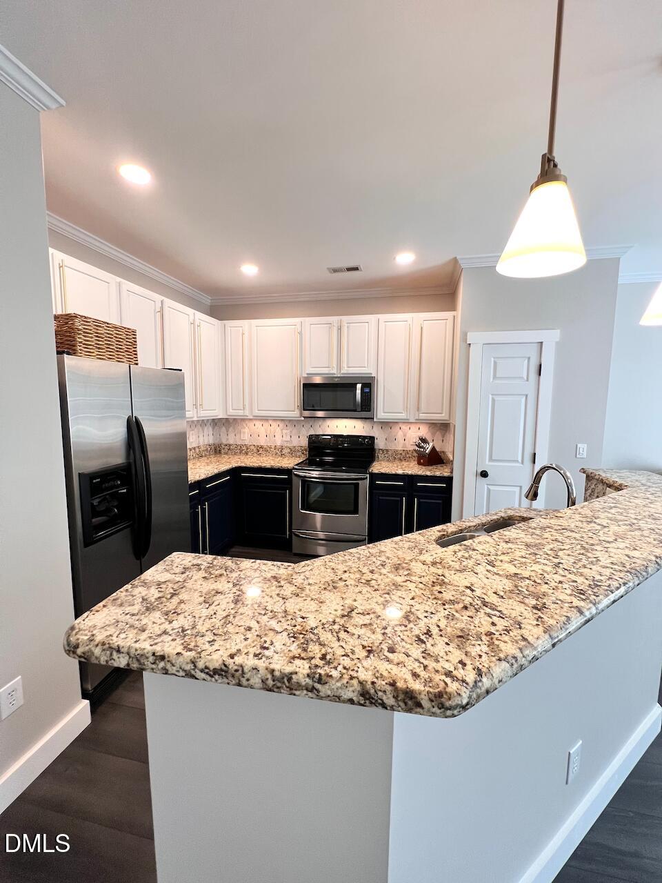 1941 Lost Lane Raleigh, NC 27603 - Photo 11 of 25 a kitchen with granite countertop a refrigerator a stove a sink a center island and wooden cabinets