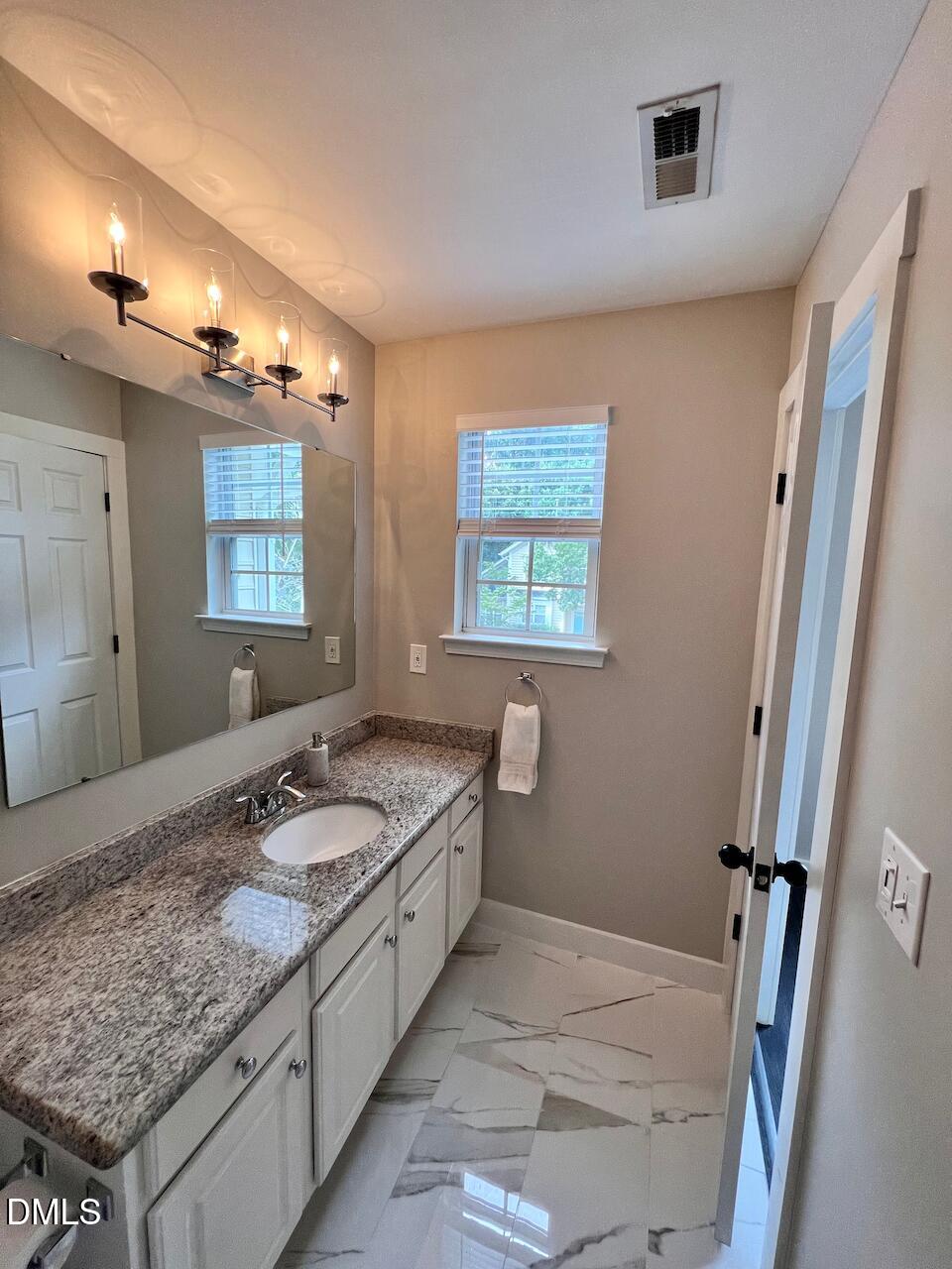 1941 Lost Lane Raleigh, NC 27603 - Photo 19 of 25 a bathroom with a granite countertop sink and a mirror