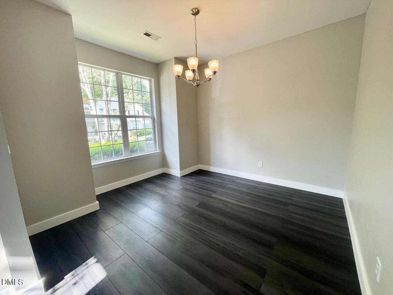 1941 Lost Lane Raleigh, NC 27603 - Photo 23 of 25 a view of an empty room with wooden floor and a window