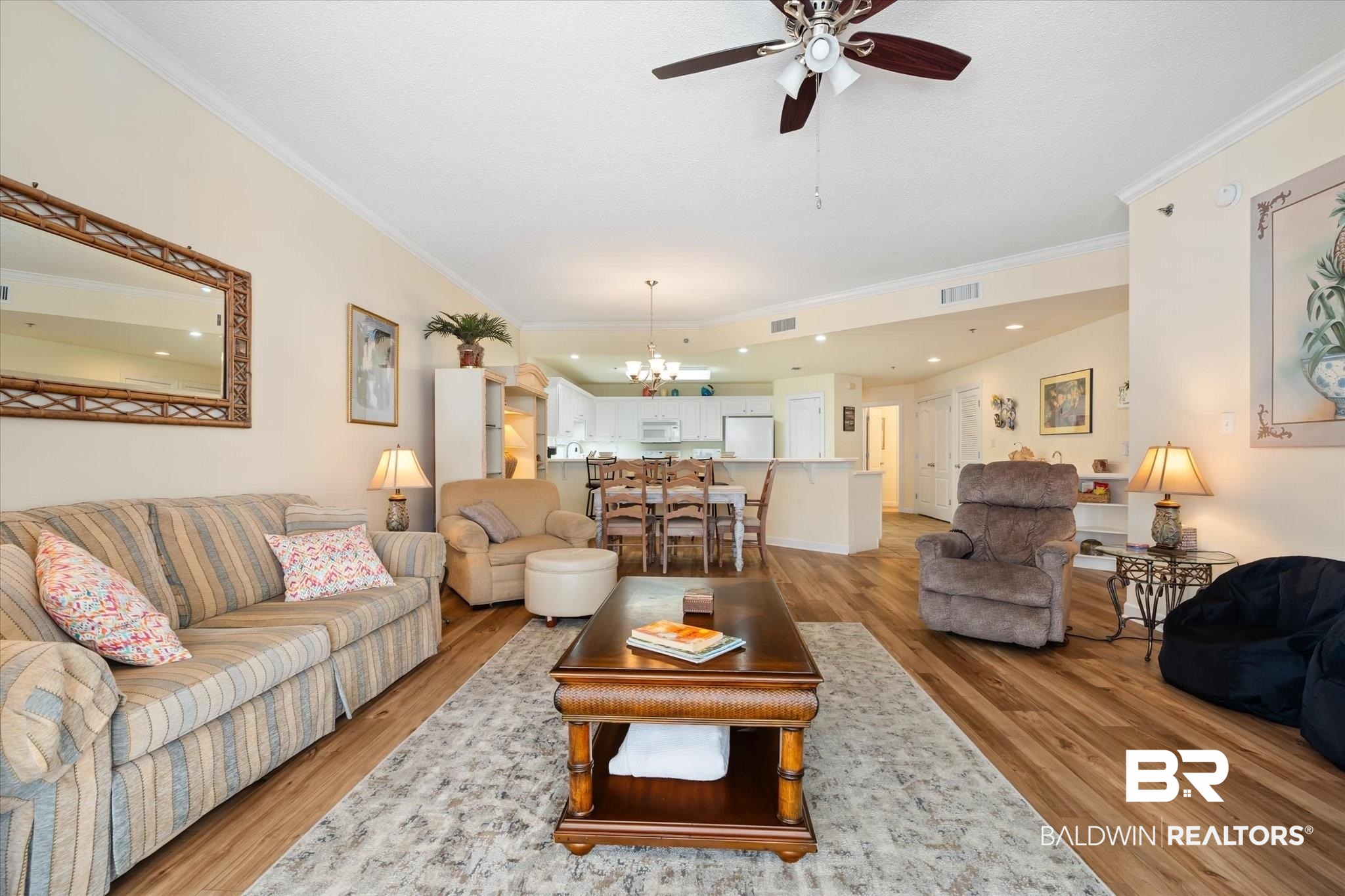 27770 Canal Road, Unit 2304 Orange Beach, AL 36561 - Photo 12 of 30 Living area featuring light wood-style floors, visible vents, crown molding, and ceiling fan with notable chandelier