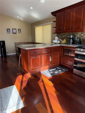 a kitchen with granite countertop a stove a sink and a cabinets