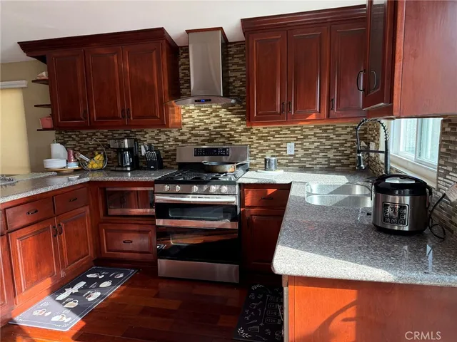 a kitchen with stainless steel appliances granite countertop a stove a sink and a microwave