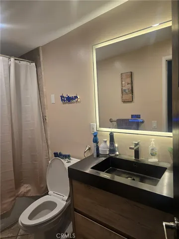 a bathroom with a sink a toilet and a mirror