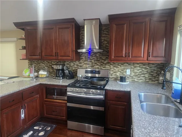 a kitchen with granite countertop a sink stove and cabinets