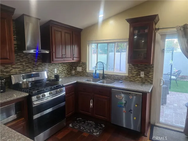 a kitchen with stainless steel appliances granite countertop a stove a sink and a microwave