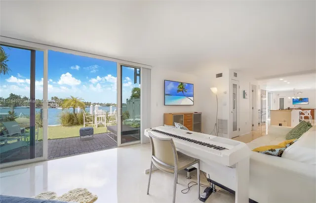 a living room with furniture a floor to ceiling window and a kitchen