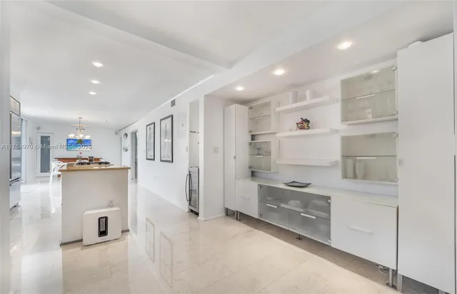 a kitchen with white cabinets and refrigerator