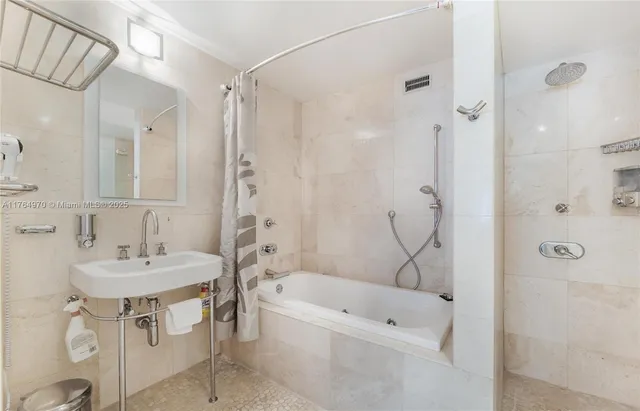 a bathroom with a bathtub shower sink vanity and a mirror