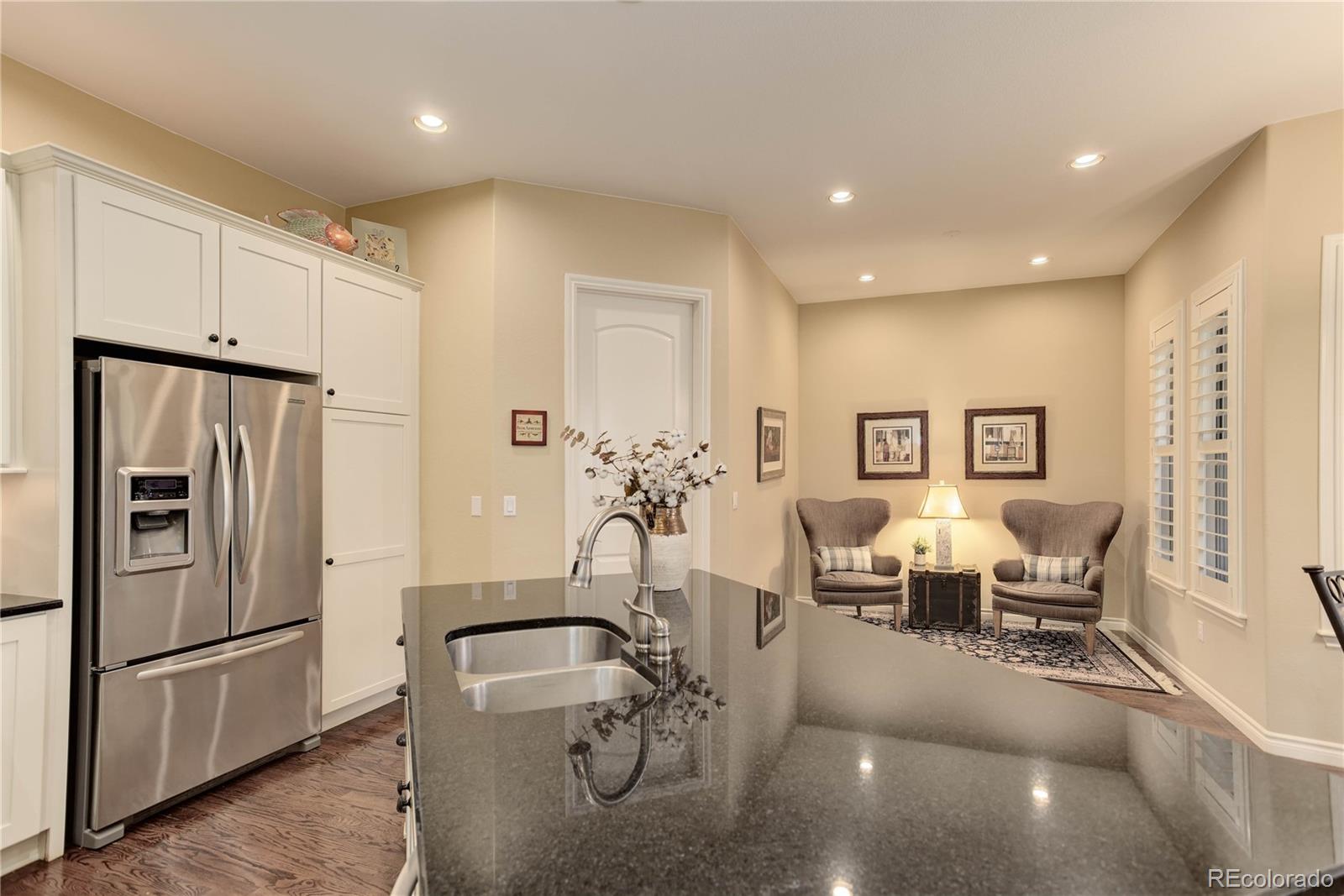 9285 Viaggio Way Highlands Ranch, CO 80126 - Photo 8 of 45 a kitchen with refrigerator and chairs