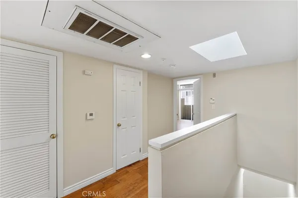 a view of hallway with stairs and wooden floor