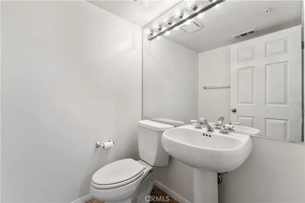a bathroom with a sink a toilet and mirror