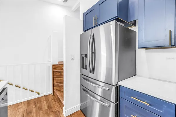 a kitchen with a stove a refrigerator and a sink with wooden floor