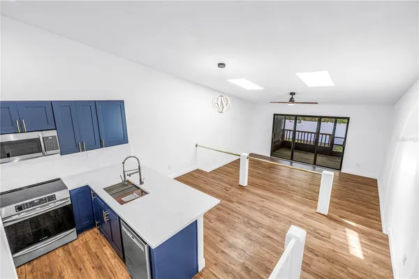 a kitchen with kitchen island a sink appliances and cabinets