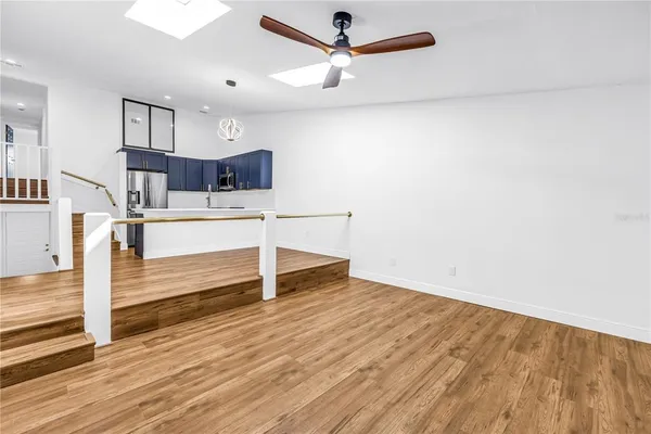 a kitchen with wooden floors and white cabinets