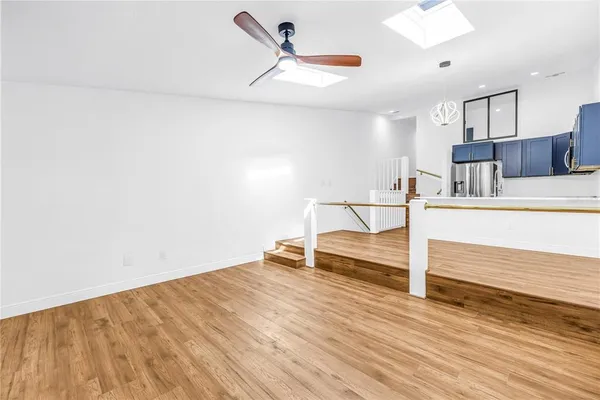 a kitchen with a sink a refrigerator and wooden floor